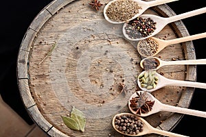 Colourful aromatic various spices for cooking on old wooden barrel, close-up, flat lay, selective focus, copy space.