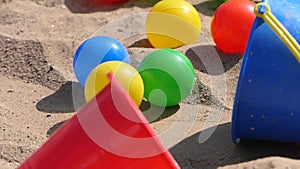 Colourful balls buckets and spades in childs sand pit