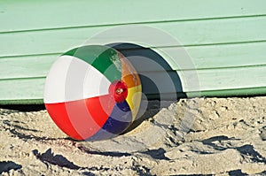 Colourful beach-ball in front of a green boat