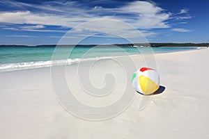 Colourful beach ball on the seashore by the ocean