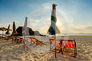 Colourful beach chairs on the white sand beach.