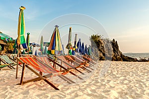 Colourful beach chairs on the white sand beach.