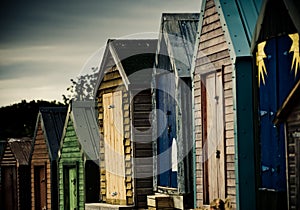 Colourful beach huts with dramatic sky