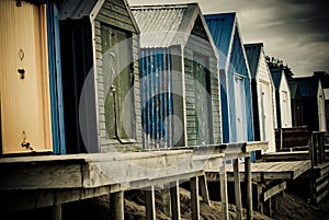 Colourful beach huts with dramatic sky