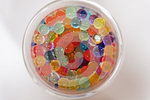 Colourful beads balls on a circle drinking glass on a white background