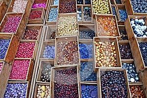 Colourful beads in different sizes and shapes sold in wooden compartment