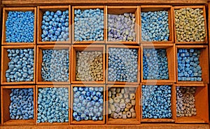 Colourful beads in different sizes and shapes sold in wooden compartment