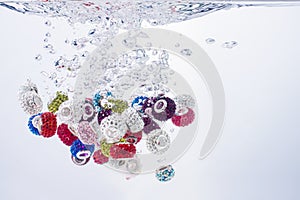 Colourful beads falling into water