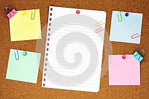 Colourful blank note paper on brown corkboard