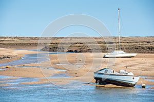 Colourful boats marooned on sandbanks