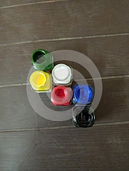 Colourful bottle of paint different colours red white black blue green and black bird eye view