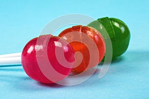 Colourful candies, a close-up at the blue background, a sweet notion of lollipops