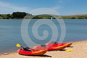 Colourful canoes by lake with blue sky