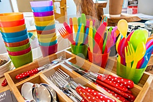 Colourful child safe plastic cutlery, adult cutlery and stacked cups