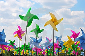 Colourful children`s pinwheels in the blue sky