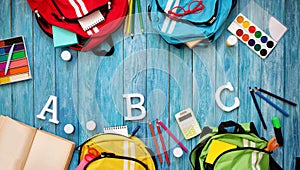 Colourful children schoolbags on wooden floor