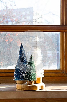 Colourful Christmas trees on the window. Trendy home decor for winter holidays