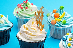 Colourful cupcakes with different modern decoration on light grey background