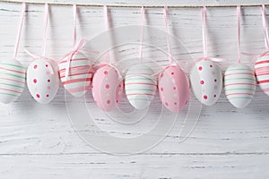 Colourful easter eggs hanging on a rope on a wooden background