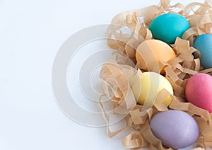 Colourful easter eggs on hay isolated over white background. Close up