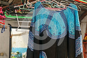 Colourful hooded festival ponchos tightly packed on a clothes rail