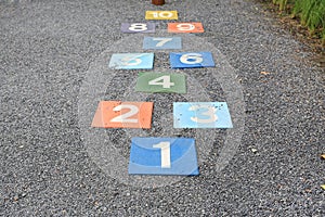 Colourful hopscotch playground markings numbers on stone at Pavement