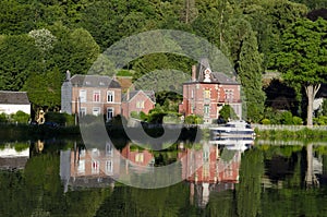 Colourful houses and tourist boats cruising along the River Meuse, Dinant, Namur, Belgium