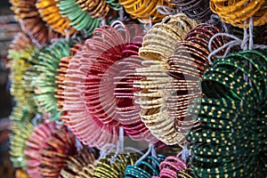 Colourful Indian wrist bracelets stacked in piles on display at a shop in Kolhapur,