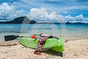 Colourful kayak on the beach. Sea, islands and beautiful clouds on the background