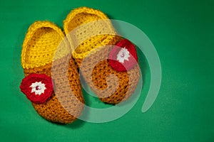 Colourful knitted Slippers on a green background