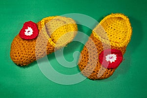 Colourful knitted Slippers on a green background