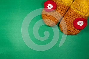 Colourful knitted Slippers on a green background