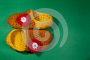 Colourful knitted Slippers on a green background