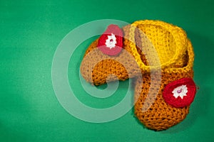 Colourful knitted Slippers on a green background