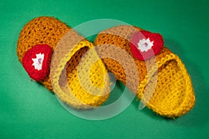 Colourful knitted Slippers on a green background