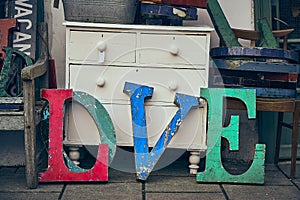 Colourful lettering outside a junk shop on a pavement