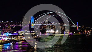 Colourful Light show at night on Sydney Harbour NSW Australia. The bridge illuminated with lasers and neon coloured lights