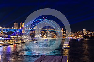 Colourful Light show at night on Sydney Harbour NSW Australia. The bridge illuminated with lasers and neon coloured lights