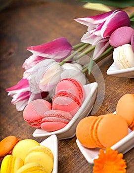 Colourful macaroons and tulips on table