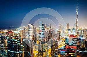 Colourful nighttime skyline of Dubai with world`s tallest skyscrapers