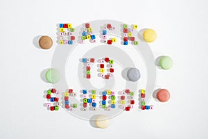 Colourful number beads in words Back To School and Macarons cookies on white background.