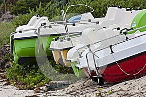 Colourful paddle-boats on a beach