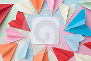 Colourful paper airplane and blank white memo paper pad on colorful pastel background