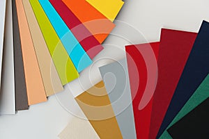 Colourful paper swatches on white desk, closeup detail