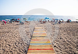 Colourful path on beach with sunbathers