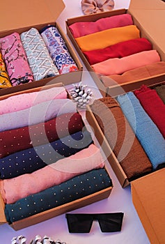 Colourful plain and printed fabrics, cloth, hijabs or scarves in boxes. Textile industry photography or product photography