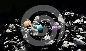 Colourful plastic balls on coal surface