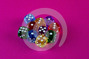 Colourful Plastic Dice Cubes on a Pink Table Surface