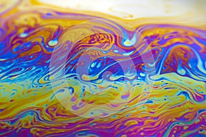 Colourful psychedelic soap bubble refractions pattern macro.