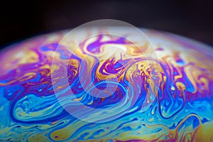 Colourful psychedelic soap bubble refractions pattern macro.